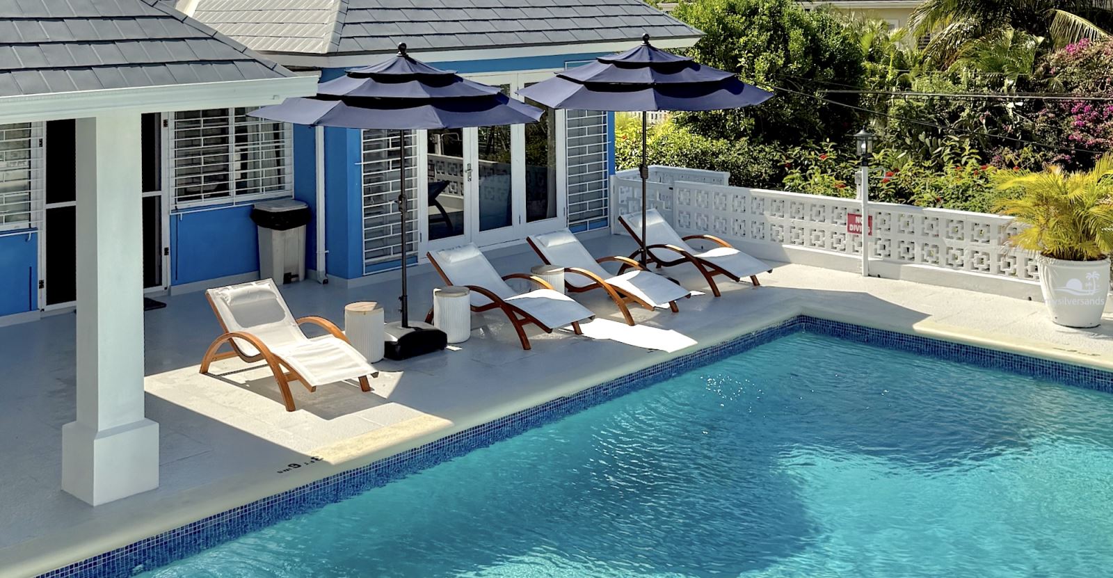 blue vista pool and chairs and villa