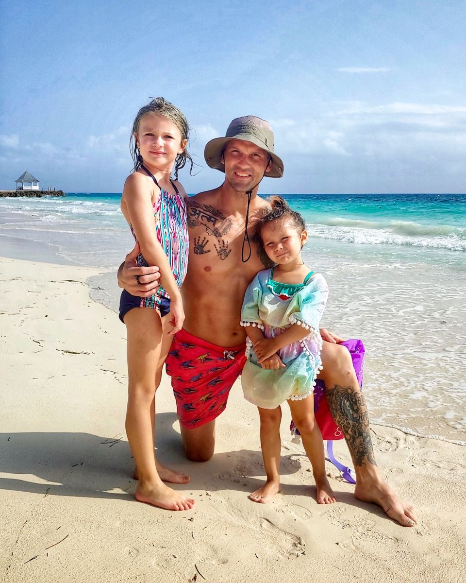 father and 2 daughters on the beach