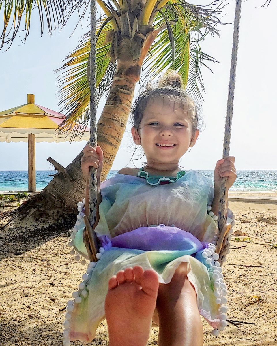 child on the swing at the beach at silver sands jamaica