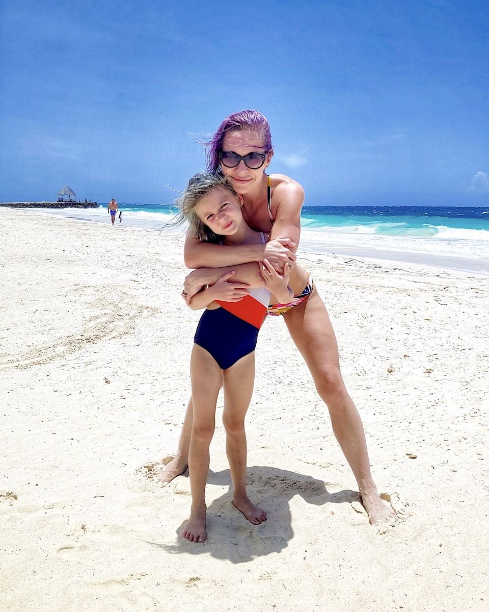 mother and daughter standing on the silver sands beach