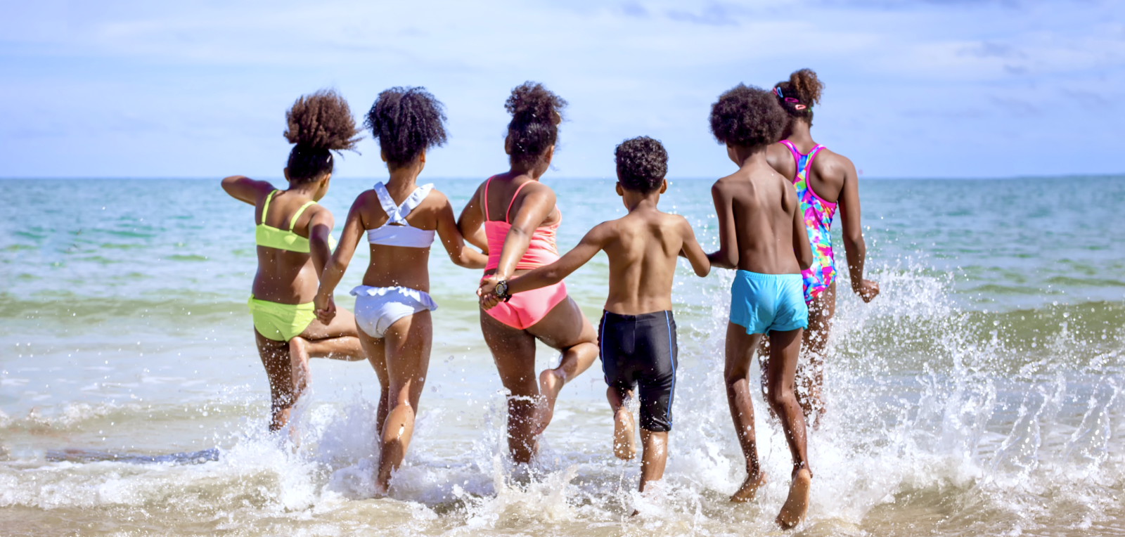 Kids playing running on sand at the beach